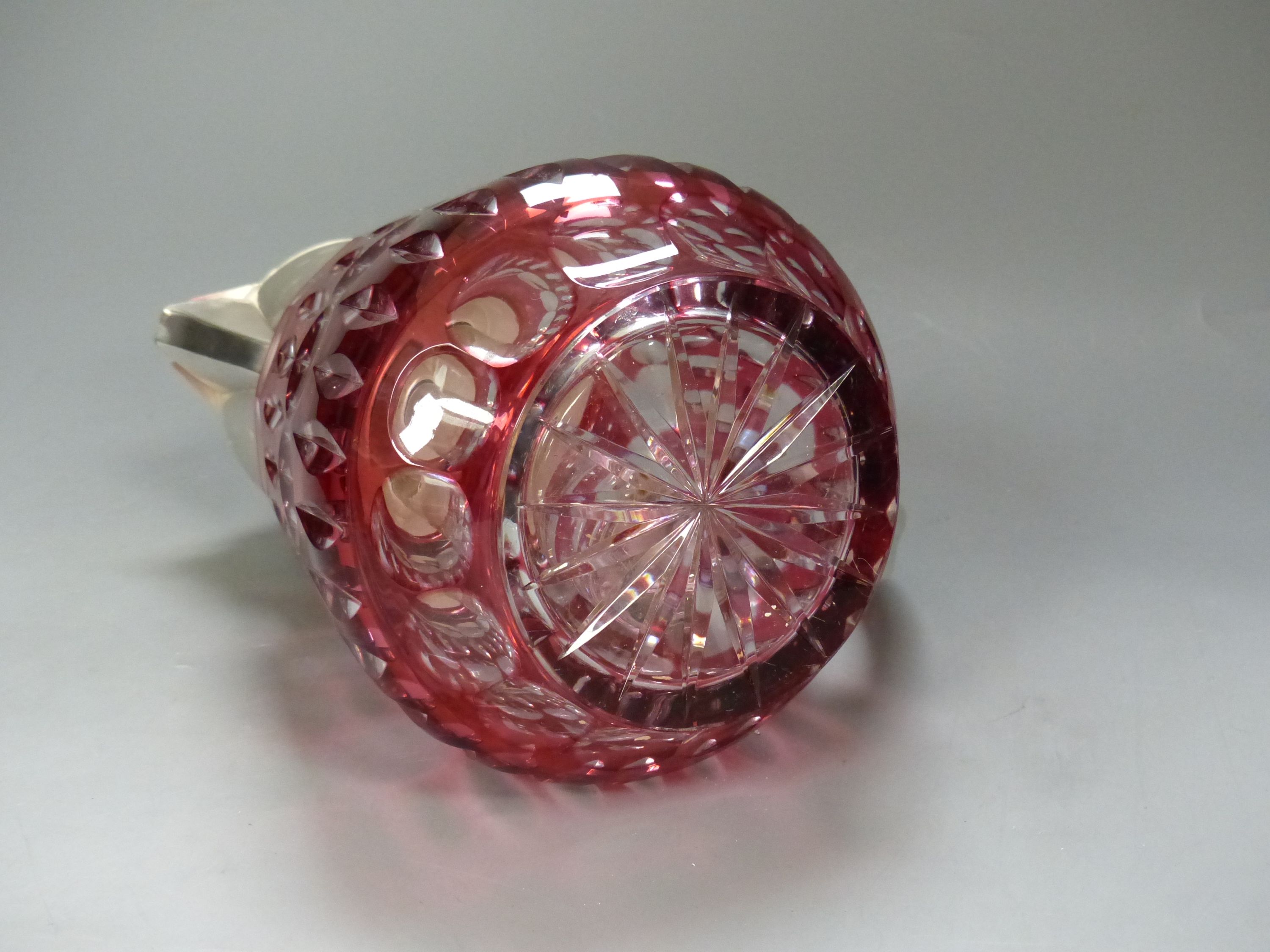 A large cranberry overlay cut glass lemonade jug with plated cover and handle, with removable ice tube, height 27cm